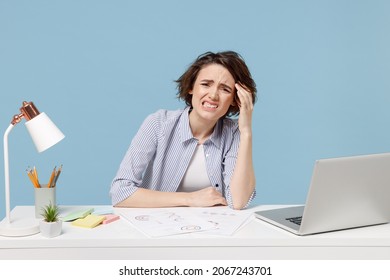 Young confused disappointed troubled secretary employee business woman in casual shirt sit work at white office desk with pc laptop prop up forehead isolated on pastel blue background studio portrait