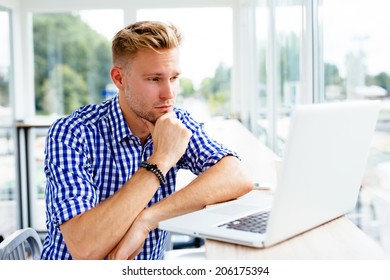 Young Confused Man Looking At A Laptop Screen