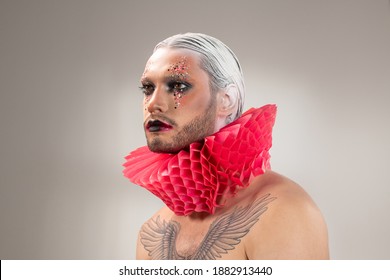 Young Contemporary Actor With Stage Makeup, White Hair In Accurate Hairdo And Tattoo On Chest Wearing Red Paper Jester Collar Around Neck