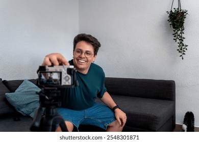 Young content creator adjusting camera for recording video blog at home
