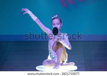 Young contortionist posing with a mirror on a stage table. Concept: Artistic circus performance, stage storytelling, and youth entertainment