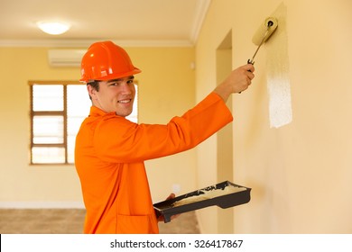 Young Contractor Painting Wall Inside The House