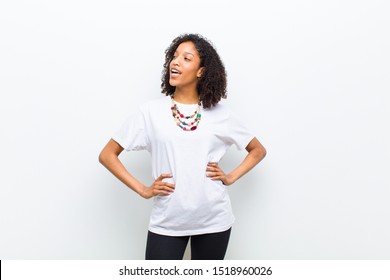 young cool african american woman looking happy, cheerful and confident, smiling proudly and looking to side with both hands on hips - Powered by Shutterstock