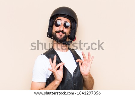 young cool bearded man with a helmet looking successful. motorbike rider concept