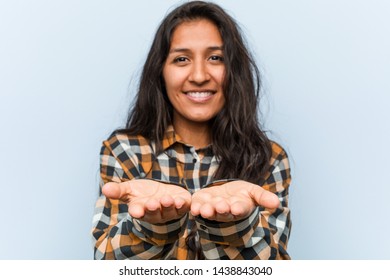 Young Cool Indian Woman Holding Something With Palms, Offering To Camera.