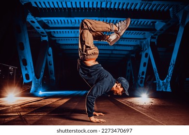 Young cool man break dancer posing on urban bridge at night - Powered by Shutterstock