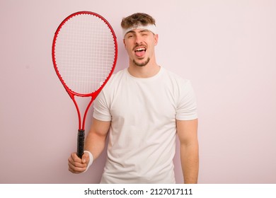 Young Cool Man With Cheerful And Rebellious Attitude, Joking And Sticking Tongue Out. Tennis Concept