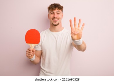 young cool man smiling and looking friendly, showing number four. pingpong concept