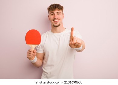 young cool man smiling proudly and confidently making number one. pingpong concept