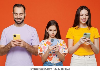 Young Cool Parents Mom Dad With Child Kid Daughter Teen Girl In Basic T-shirts Hold In Hand Use Mobile Cell Phone Isolated On Yellow Background Studio Portrait Family Day Parenthood Childhood Concept