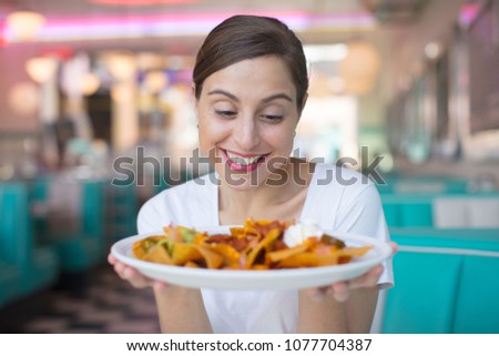 young cool woman with nachos in an american dinner restaurant