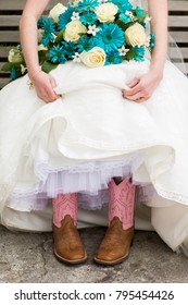 A young country girl shows her cute pink boots in a rustic wedding
