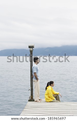 Young coupe looking at view on jetty