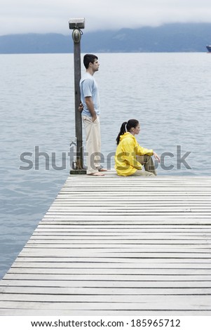 Young coupe looking at view on jetty