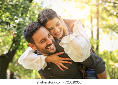 Young coupe in park. Boyfriend carrying his girlfriend on piggyback.  - Shutterstock ID 723020353