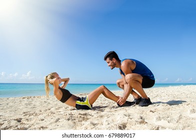 Young couple abs training at the beach - Powered by Shutterstock