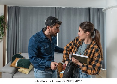 Young couple arguing because the woman lost her house or car keys from her purse and a man hands try to find them in her bag with mad facial expression and anger