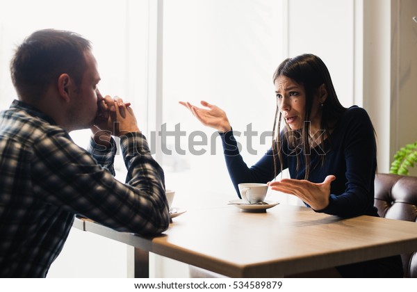 Young couple arguing in a cafe. Relationship problems.