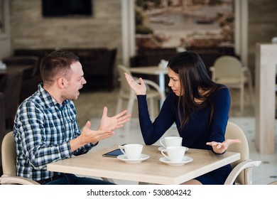 Young couple arguing in a cafe. She's had enough, boyfriend is apologizing. Relationship problems. - Powered by Shutterstock