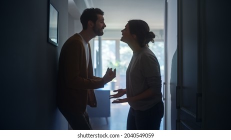Young Couple Arguing and Fighting. Domestic Violence and Emotional abuse Scene, Stressed Woman and aggressive Man Screaming at Each other in the Dark Hallway of Apartment. Dramatic Scene - Shutterstock ID 2040549059