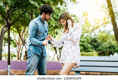 Young Couple Arguing Misunderstanding In A Park, Unhappy Couple Standing Arguing In A Park. Disgusted Teenage Couple Arguing In A Park, Man And Woman Arguing In A Park