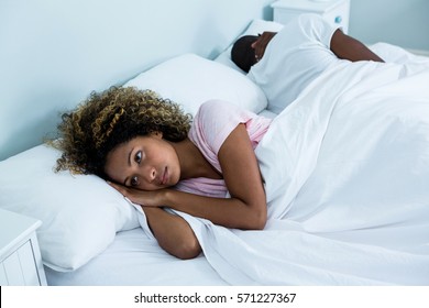 Young couple back to back ignoring each other in the bedroom