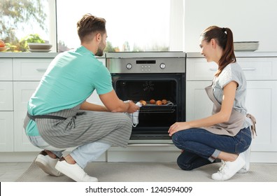 Young couple baking croissants in oven at home - Powered by Shutterstock