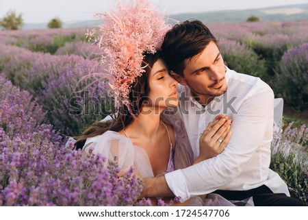 Young couple beautifully smile at each other at sunset.Guy and girl enjoy each other. Lovers looking at each other. Romantic date in the rays of the sunset.