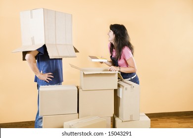 Young couple being silly with moving boxes at home - Powered by Shutterstock