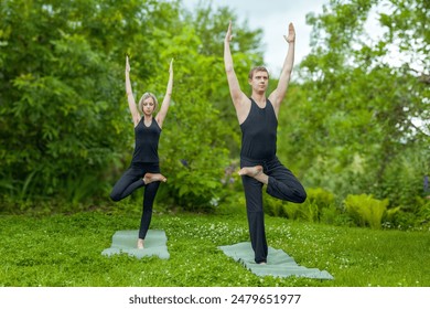 Young couple in black attire meditating in yoga position on poolside. Perfect for wellness, fitness, and lifestyle themes. Ideal for promoting yoga retreats, mindfulness apps, or health magazines. - Powered by Shutterstock