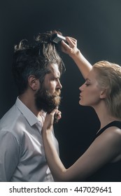 Young Couple Of Blonde Pretty Hairdresser Combing With Brush Male Brunette Hair Of Handsome Bearded Man With Long Beard In White Shirt On Grey Background