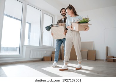 Young Couple With Boxes Moving In New Flat, New Home And Relocation Concept.