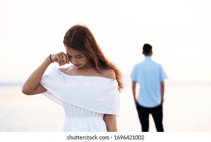 Young Couple Break Up At The Sea Deck. Girl Crying And Walk Away From Man In Concept Love Hurts,hard Relationship,sad Love Story,when Love Is Ended. Broken Heart Syndrome. How To Fix A Broken Heart.