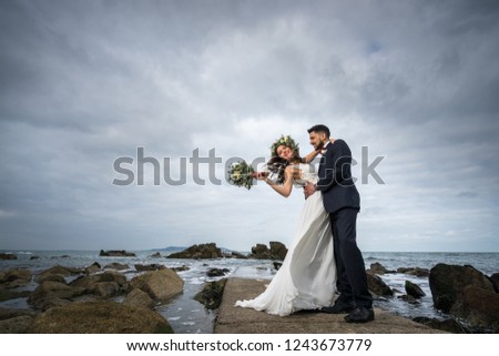 young couple bride groom getting married wedding posed photos at seaside sea beach hairpiece flowers bouquet 