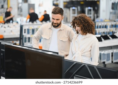 Young couple browsing in a consumer electronics store, comparing options while considering the latest televisions for their home entertainment setup