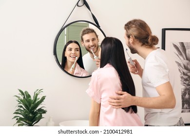 Young couple brushing teeth in bathroom - Powered by Shutterstock