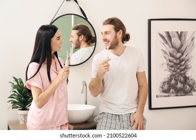 Young Couple Brushing Teeth In Bathroom