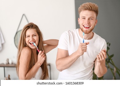 Young Couple Brushing Teeth At Home