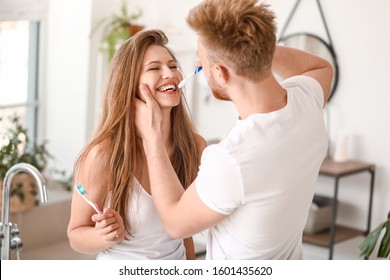 Young Couple Brushing Teeth At Home