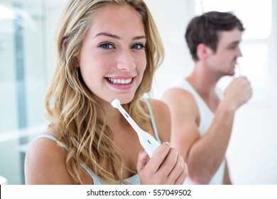 Young couple brushing their teeth at home in the bathroom