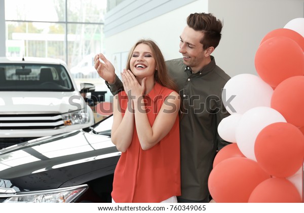 Young couple buying car in\
salon