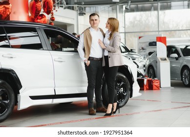 Young Couple Buying A Car In A Car Showroom