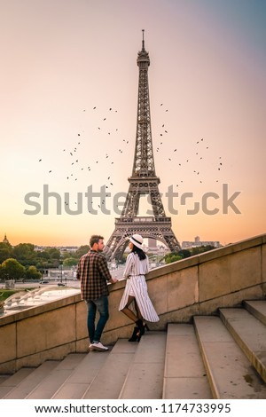Young couple by Eiffel tower at Sunrise, Paris Eifel tower Sunrise man woman in love, valentine concept in Paris the city of love. Men and women visiting Eiffel tower
