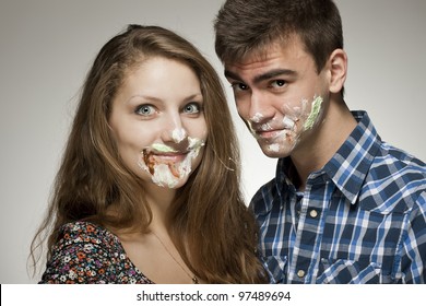 Young Couple With Cake On Face.