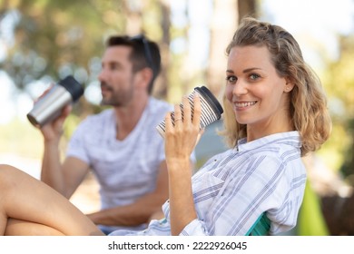 Young Couple Of Campers Drinking Tea Outside