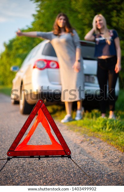 Young couple in a car with a red triangle in\
the foreground