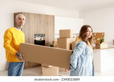 Young couple carrying box in kitchen on moving day - Powered by Shutterstock