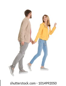 Young couple in casual clothes walking on white background