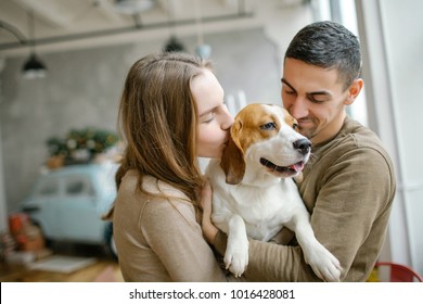 Young couple of caucasian male and female with beagle in dining room - Powered by Shutterstock