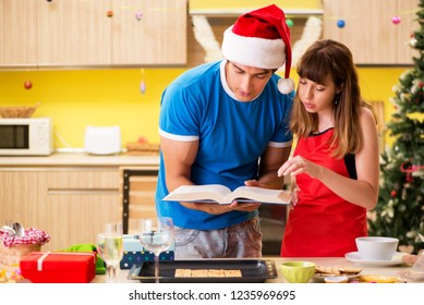 Young Couple Celebrating Christmas In Kitchen 